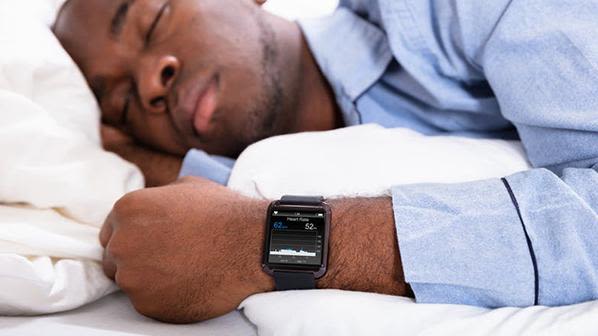 Man asleep wearing sleep tracker on his wrist