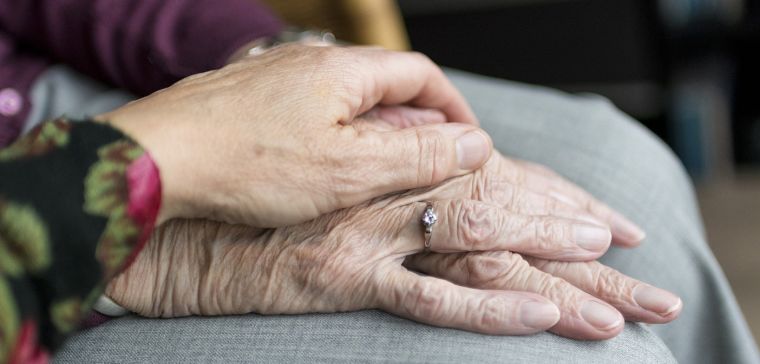 A young person's hand on an older person's hand