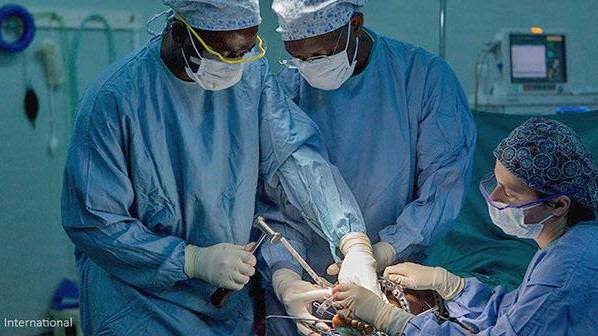Three surgeons working in operating theatre